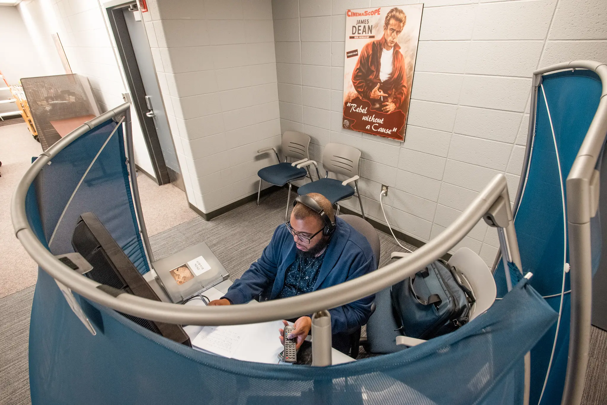 Aerial view of student sitting inside the viewing station, wearing headphones 