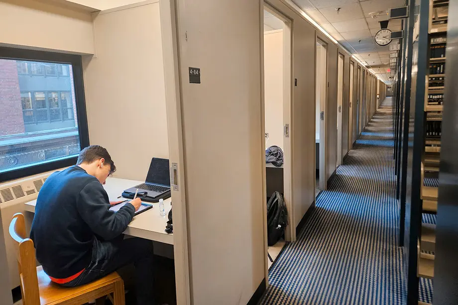 A row of carrels with no doors to the left and stacks on the right.